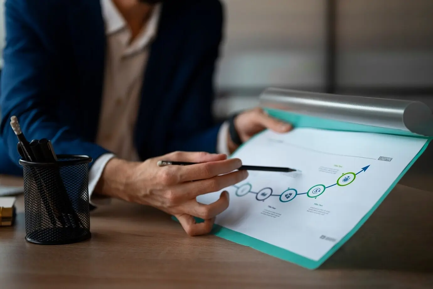 Une personne au bureau en train d’analyser et de vérifier des graphiques financiers.