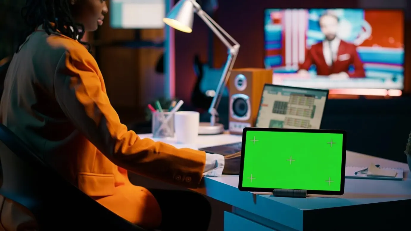 Un élève afro-américain regarde l’écran à fond vert d’une tablette.